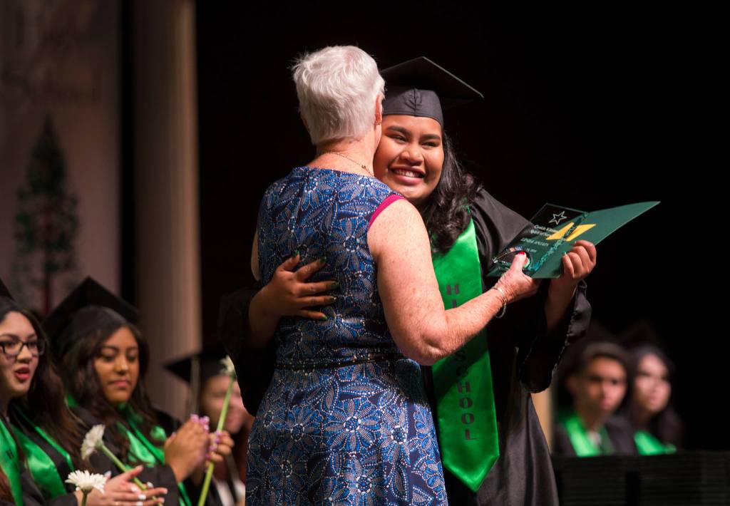 Linda Anjain (right) gets a hug from Cookie Kitzman after receiving the Spirit of Sequoia Award from Kitzman during the Sequoia High School graduation ceremony at the Everett Civic Auditorium on Thursday. (Andy Bronson / The Herald)