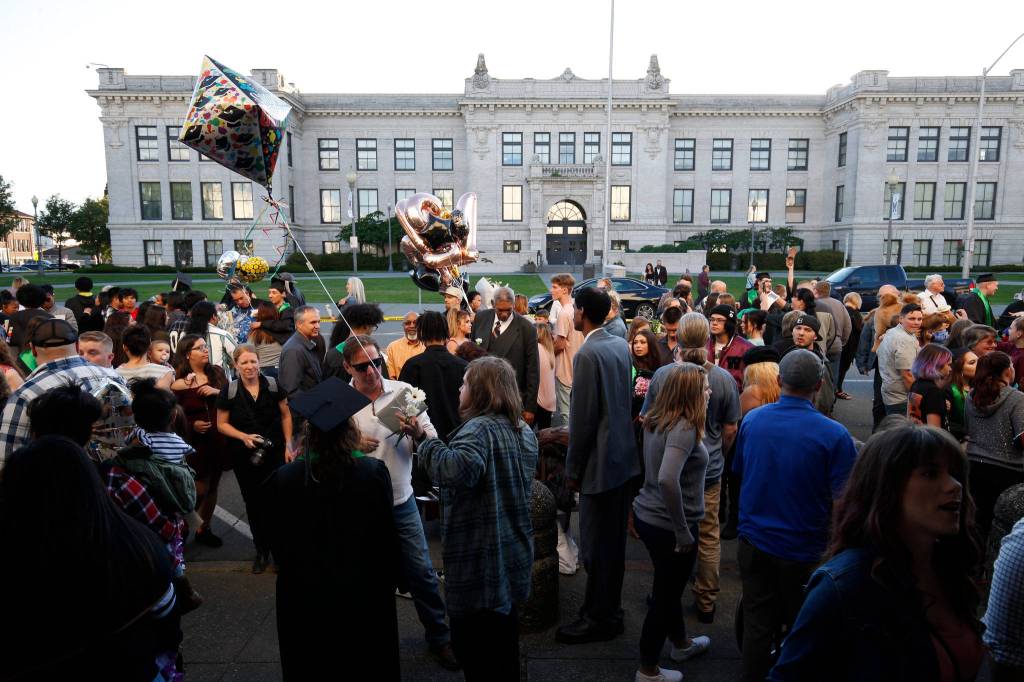 Graduates and family members mingle outside after the Sequoia High School graduation ceremony at the Everett Civic Auditorium on Thursday. (Andy Bronson / The Herald)
