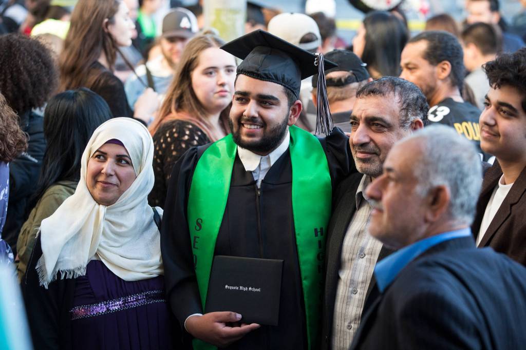Ali Almiahi poses for a photo with family members after the Sequoia High School graduation ceremony at the Everett Civic Auditorium on Thursday. (Andy Bronson / The Herald)
