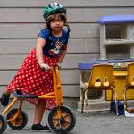 Five-year-old Autumn climbs onto a sturdy tricycle in the playground area at Tomorrows Hope Child Development Center in Everett Friday. (Dan Bates / The Herald)