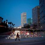 In this 2017 photo, a woman walks on a bridge as heavy traffic moves along the 110 Freeway during rush hour in Los Angeles. From drivers paying more for gas and families bearing heavier child care costs to workers still awaiting decent pay raises to couples struggling to afford a home, people throughout the economy are straining to succeed despite the economys gains. (AP Photo/Jae C. Hong, File)