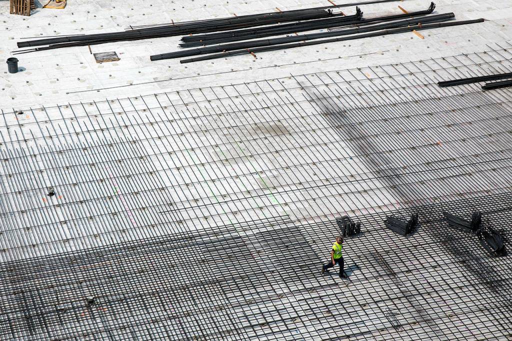 A worker crosses over what will be the new parking garage for the Northgate Station in August 2017. (Lizz Giordano / The Herald)