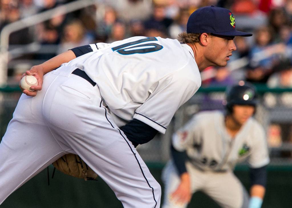 AquaSox pitcher Max Roberts looks for the signal with the Hops Andy Yerzy leading off first base during opening night on June 15, 2018, at Everett Memorial Stadium. (Kevin Clark / The Herald)
