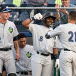 The Hops Joey Rose (21) makes his way to the dugout to celebrate with teammates Ryan January (4) and Keshawn Lynch (8) after hitting a home run in the third inning against the AquaSox on June 15, 2018, at Everett Memorial Stadium. (Kevin Clark / The Herald)