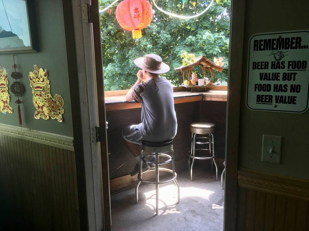 Khoa Nguyen, of Everett, waits for his lunch order of pineapple fried rice on the outdoor patio overlooking the railroad tracks at the Riverview Market & Cafe in Everett on June 6. Read the story <a href="https://www.heraldnet.com/news/med-schools-got-nothing-on-this-tiny-market-in-lowell/" target="_blank">here</a>. (Sue Misao / The Herald)
