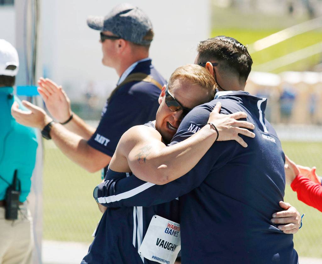 Navy Chief Petty Officer Tim Vaughn (left), of Marysville,hugs track coach Kyle Putnam (right) after Vaughn competed in the mens 1500 meters at the U.S. Air Force Academy near Colorado Springs, Colorado, onJune 2 . Vaughn is an athlete competing in the ninth edition of the Department of Defense Warrior Games. (Photo/Zoe L. Smith, Grady Sports Bureau)