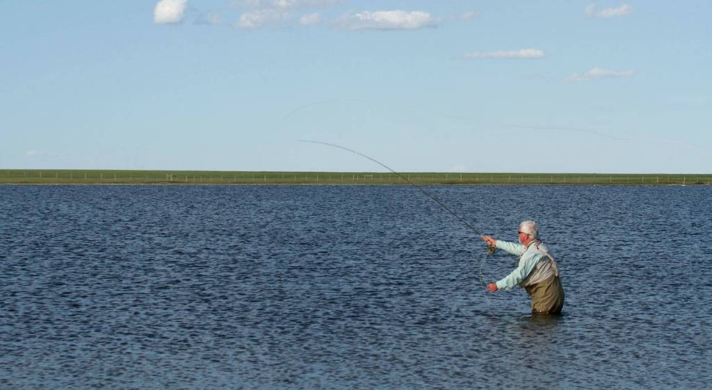 Dick Snow of Marysville casts for fish along the shoreline of Montanas Mission Lake. (Photo by Mike Benbow)
