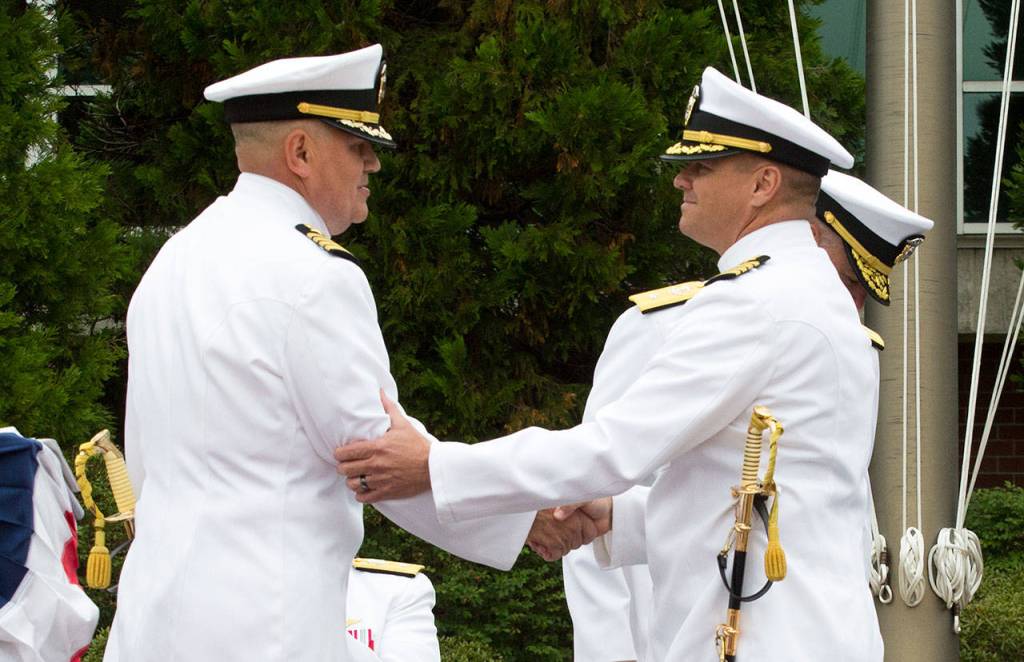 Capt. Mike Davis (right) shakes the hand of Capt. Mark Lakamp, relieving him as commanding officer of Naval Station Everett during the Change of Command Ceremony on Friday. (Andy Bronson / The Herald)