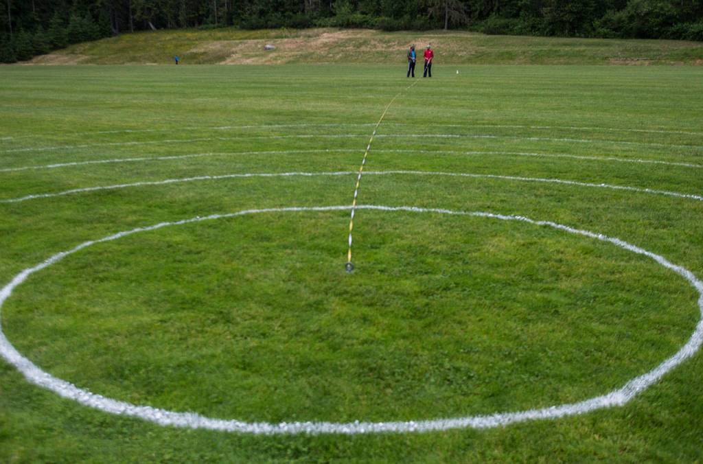 Richard Bower, left, and Daniel Bower work on measuring and painting the lines for the upcoming U.S. Boomerang National Championships at Lake Stevens Community Park on Friday, June 22, 2018. (Olivia Vanni / The Herald)