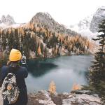 A hiker stops to take a photo with her cellphone in the North Cascades. (Unsplash)