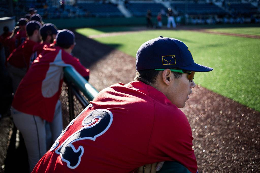 An Alaska state flag decorates the hat of Kyle Knell as he watches his team, the Goldpanners, play the first game of a three-game series against the Everett Merchants at Everett Memorial Stadium on June 26. (Andy Bronson / The Herald)