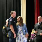Jamie Dowell looks closely at a pin she placed on her husband, Cory Dowell, at his graduation from Snohomish Countys first fire academy on June 27. (Caleb Hutton / The Herald)