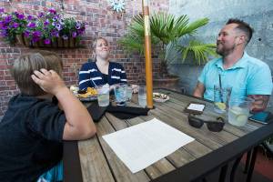 Becca Selin and her son, Brody, share a laugh with Erik Marty during Taco Tuesday at Sol Food Bar and Grill in Everett. Marty put out a question looking for a dining companion on a Facebook dining page. Within 90 minutes, Selin answered and brought along Brody, 7. (Andy Bronson / The Herald)
