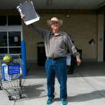 Mark Pitts waves to try to flag people down for signatures outside of Walmart last week in Everett. (Olivia Vanni / The Herald)