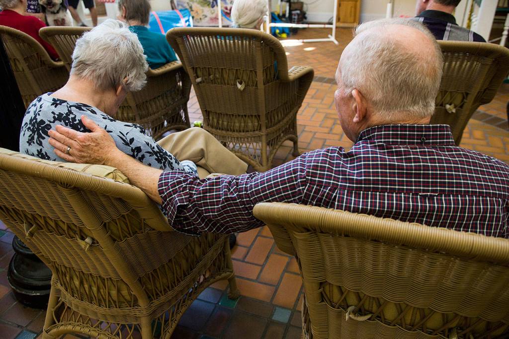 Jim Mallonee and Shirley Mallonee watch a dog perform a trick at Brookdale Silver Lake. (Olivia Vanni / The Herald)