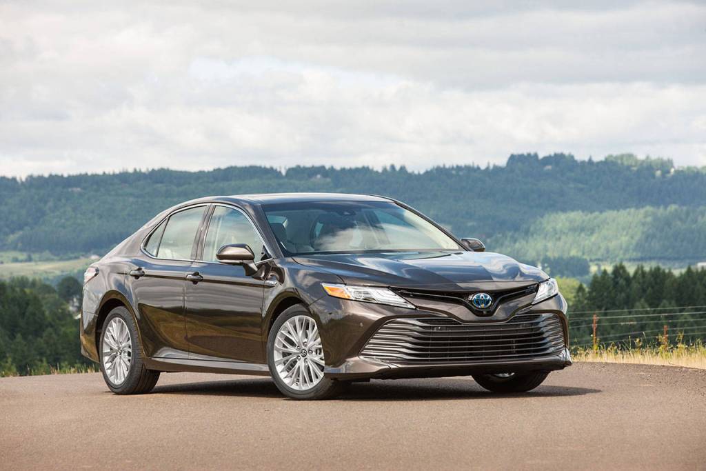 The 2018 Toyota Camry Hybrid has a two-piece grille with flowing thin and thick treatments. The hood has been lowered by 1.6 inches and the grilles uppermost section has a bold Toyota emblem tinged with blue, to distinguish it from the regular Camry. (Manufacturer photo)