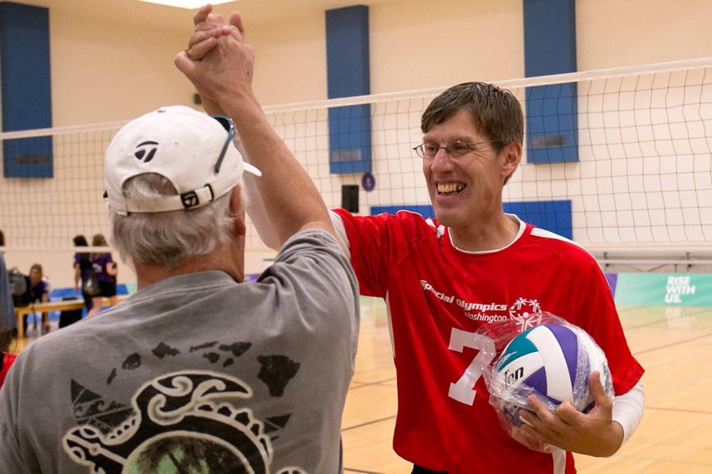 Washingtons Marcus Hall (right), from Marysville, celebrates with a fan after winning the gold medal in traditional volleyball at the 2018 Special Olympics USA Games on July 6, 2018, at Alaska Airlines Arena in Seattle. (Kevin Clark / The Herald)