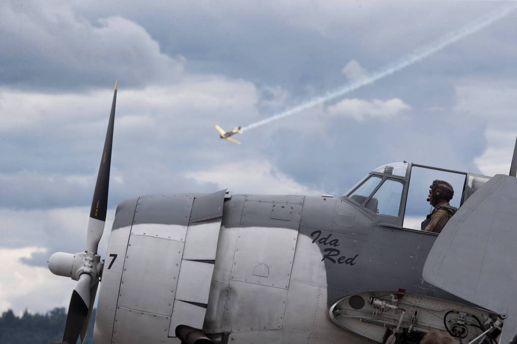 While sitting in the cockpit of the Grumman TBM-3E Avenger Ida Red, pilot Michael Kopp gets his plane ready as another plane performs at the 50th annual Arlington Fly-In at the Arlington Airport on Saturday. (Andy Bronson / The Herald)