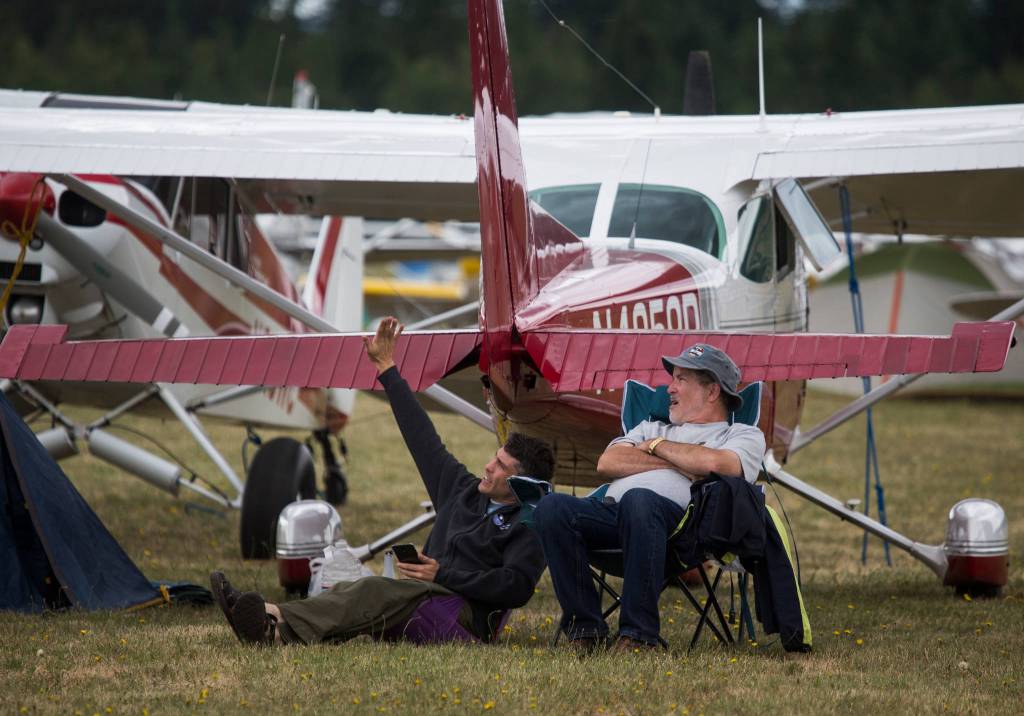 Nathan Gerhards, who flew in from Salem, Oregon, describes aerial maneuvers to his father, Ralph, at the 50th annual Arlington Fly-In at the Arlington Airport on Saturday. (Andy Bronson / The Herald)