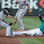 Rockies shortstop Trevor Story (left) tags out the Mariners Dee Gordon who was trying to steal second base during the first inning of a game, July 6, 2018, in Seattle. (AP Photo/Stephen Brashear)