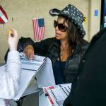 Lourdes Coria (center) helps a young woman register to vote outside of Walmart on June 27 in Everett. (Olivia Vanni / The Herald)