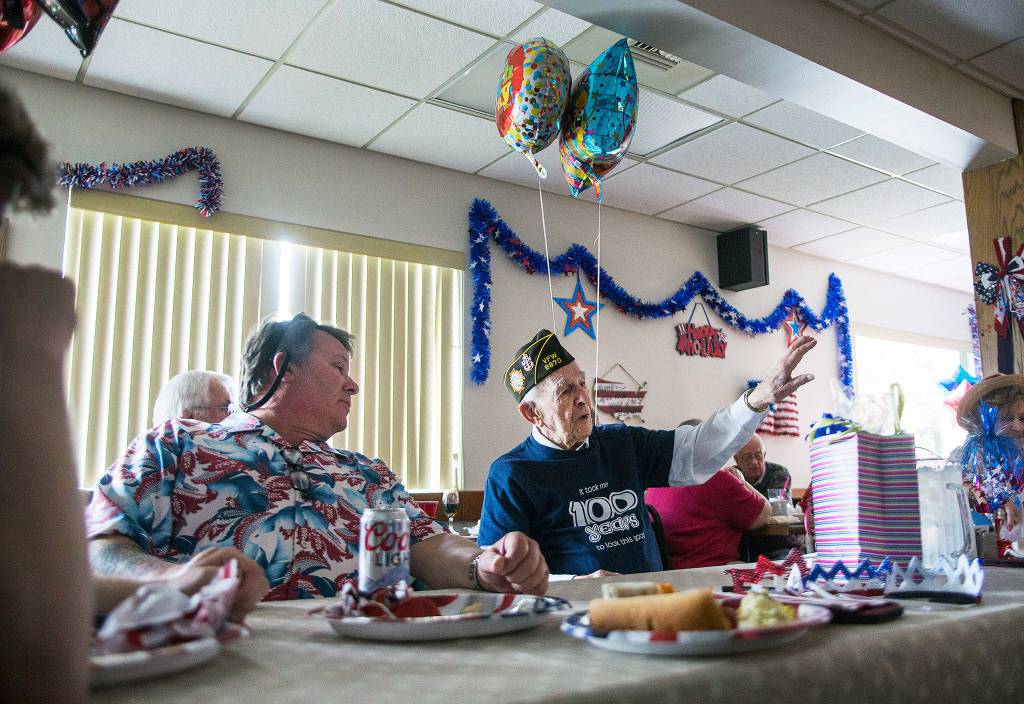 Edgar Shepherd, 100, talks to friends and family at the table during his 100th birthday celebration at the Lynnwood Elks Lodge on Wednesday, July 4, 2018 in Lynnwood, Wa. (Olivia Vanni / The Herald)
