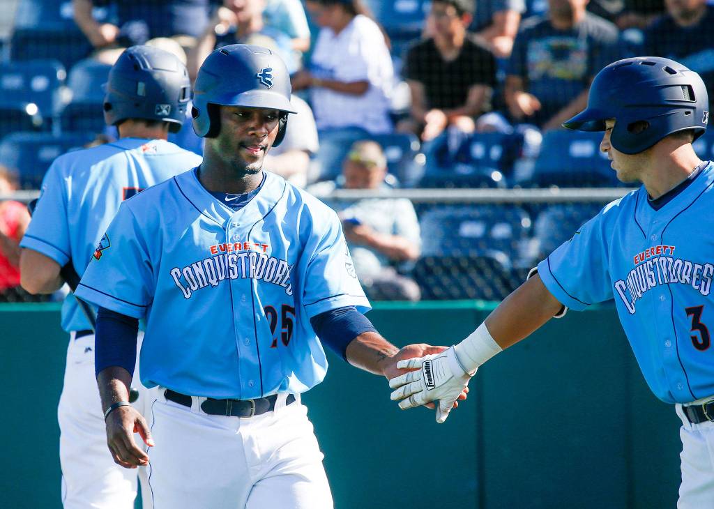 The Aquasox <a href="https://www.heraldnet.com/sports/stowers-brings-combination-of-speed-power-to-aquasox/" target="_blank">Josh Stowers</a> (25) gets a hand from teammate Bobby Honeyman after scoring a run as Everett took on Tri-City at Everett Memorial Stadium on June 24 in Everett. (Andy Bronson / The Herald)