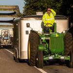Jeff Newell blocks the early morning sun from his eyes as he cruises down Highway 530, at a easy 16 miles per hour, on his John Deere tractor on Wednesday, July 11, 2018 in Arlington, Wa. Ron Wachholtz follows behind as the two raise money while driving their tractors to Prudhoe Bay, AK. They are raising money for the American Diabetes Association. (Andy Bronson / The Herald)