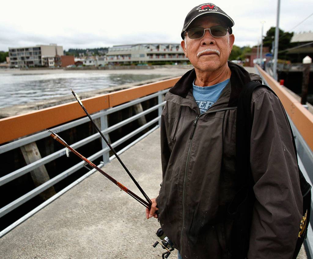 Ruben Rodriguez heads home to Seattle from the Edmonds fishing pier after several hours with no luck, but he said he will be back to try again soon. (Dan Bates / The Herald)