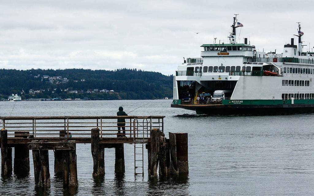 A fisherman waits for a catch at the fishing pier adjacent to the Mukilteo Ferry dock. (Dan Bates / The Herald)
