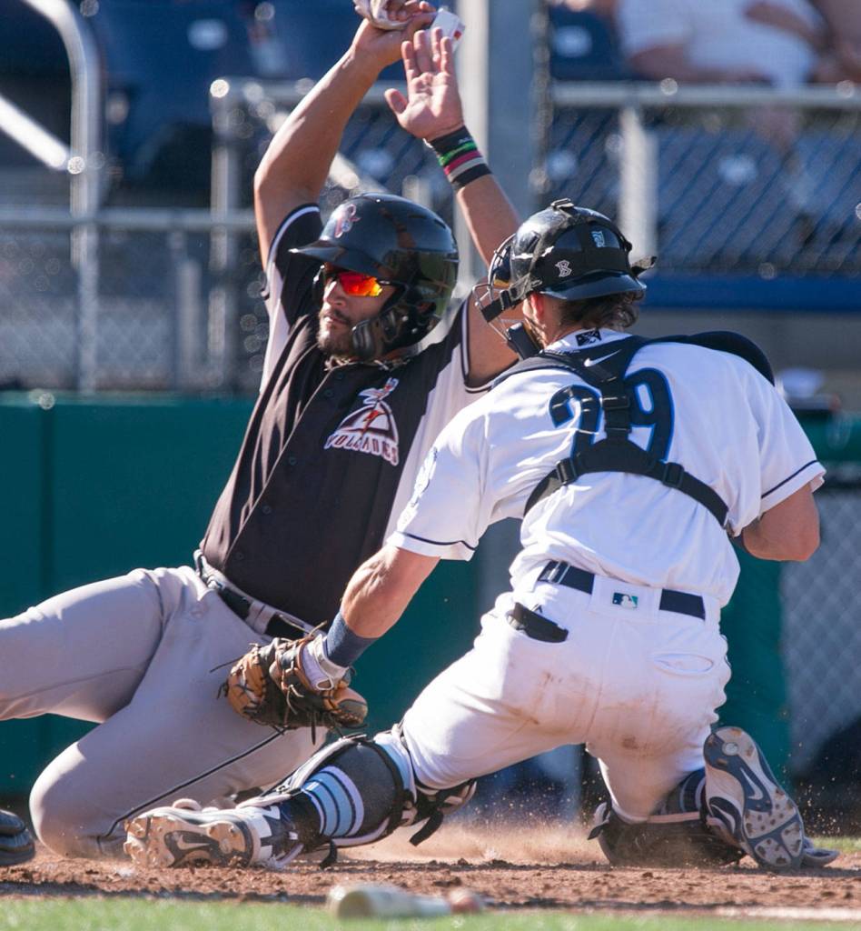 Aquasoxs Geoandry Motilla tags out Volcanos David Villar Sunday afternoon at Everett Memorial Stadium on July 15, 2018. (Kevin Clark / The Herald)