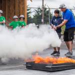 Max Williams, 12, learns how to use a fire extinguisher from Kevin Miller during Kids Fire Camp at South County Fire Administrative Headquarters on Wednesday in Everett. (Olivia Vanni / The Herald)