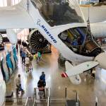 An experimental Boeing plane hangs above visitors looking at engines and planes on display at the Future of Flight on Friday in Mukilteo. The Boeing Co. plans this year to operate the Future of Flight Aviation Center. (Andy Bronson / The Herald)