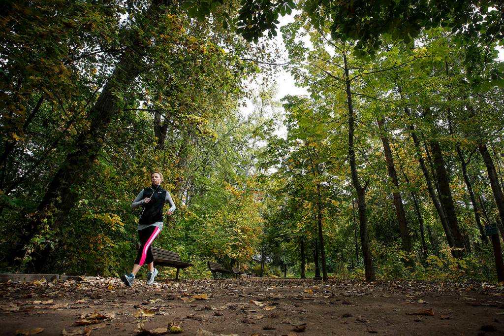 A jogger is seen along a trail in Leavenworths Waterfront Park. The park hugs the winding Wenatchee River nearby and offers views of nearby mountains. (Photo by Ian Terry)