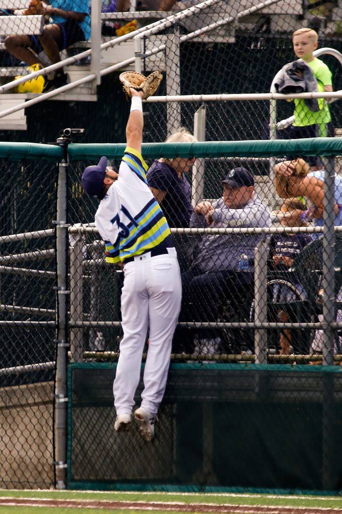 Aquasoxs Ryan Garcia reaches over the fence to make a leaping catch as the Everett Aquasox lost to the Spokane Indians 7-3 at Everett Memorial Stadium on July 18. (Andy Bronson / The Herald)