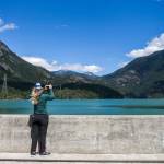 Danielle Phillips takes a photo of <a href="https://www.heraldnet.com/life/three-dams-two-lakes-and-mountains-all-around/" target="_blank">Diablo Lake from Diablo Dam</a> on June 26 in Rockport. (Olivia Vanni / The Herald)