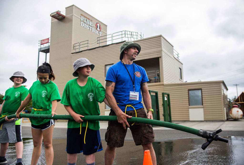 South County firefighter Phil Pons looks up after his team loses a fire house game during <a href="https://www.heraldnet.com/news/kids-doused-in-learning-fun/" target="_blank">Kids Fire Camp</a> at South County Fire Administrative Headquarters on July 18 in Everett. (Olivia Vanni / The Herald)