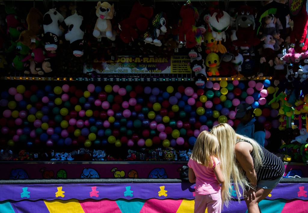 Jessie Romer talks to her daughter Jasmine Romer, 5, at the carnival during Kla Ha Ya Days on Saturday, July 21, 2018 in Snohomish, Wa. (Olivia Vanni / The Herald)