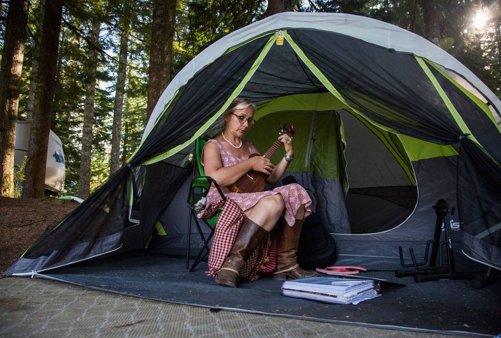 Kim Bothen plays music in her tent during the Darrington Bluegrass Festival on Saturday, July 21, 2018 in Darrington, Wa. (Olivia Vanni / The Herald)