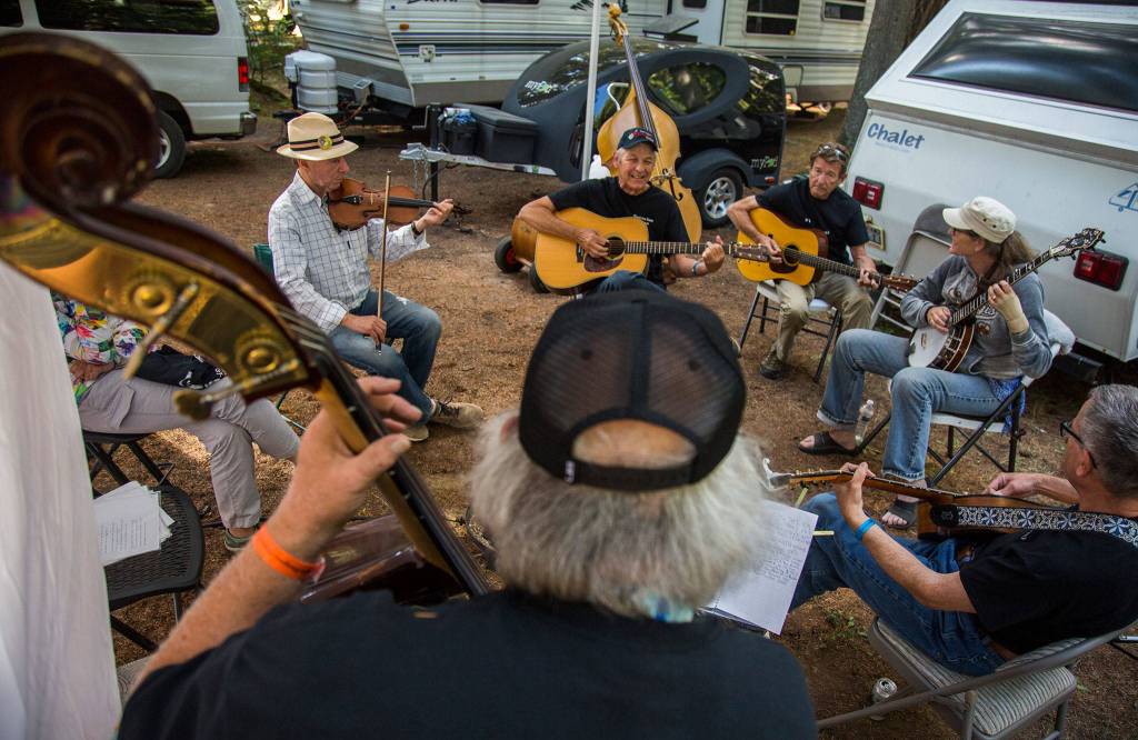From left to right, Gene Silberberg, Fred Holt, Paul Wenberg, Jana Van Amberg, Neil Massey and John Slostad gather for a practice session during the Darrington Bluegrass Festival on Saturday, July 21, 2018 in Darrington, Wa. (Olivia Vanni / The Herald)