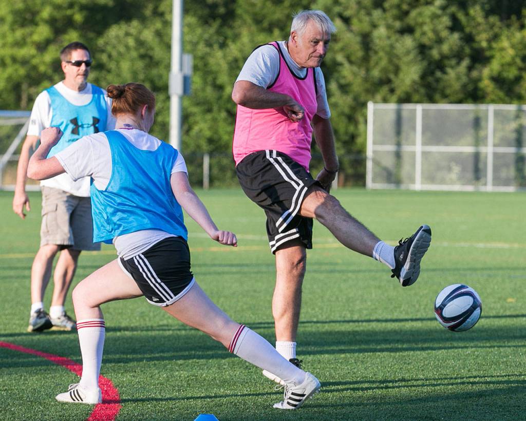 Bob Cole (right) attempts a shot with Kaari Skaugrud defending during a walk soccer game July 18 at Kasch Park in Everett. (Kevin Clark / The Herald)