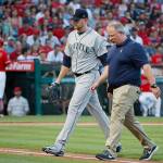 Seattles James Paxton walks off the field with a team trainer during a game against the L.A. Angels on July 12 in Anaehim, California. Paxton was expected to be activated from the disabled list Tuesday, but has experienced a setback in his recovery from a back injury. (AP Photo/Jae C. Hong)