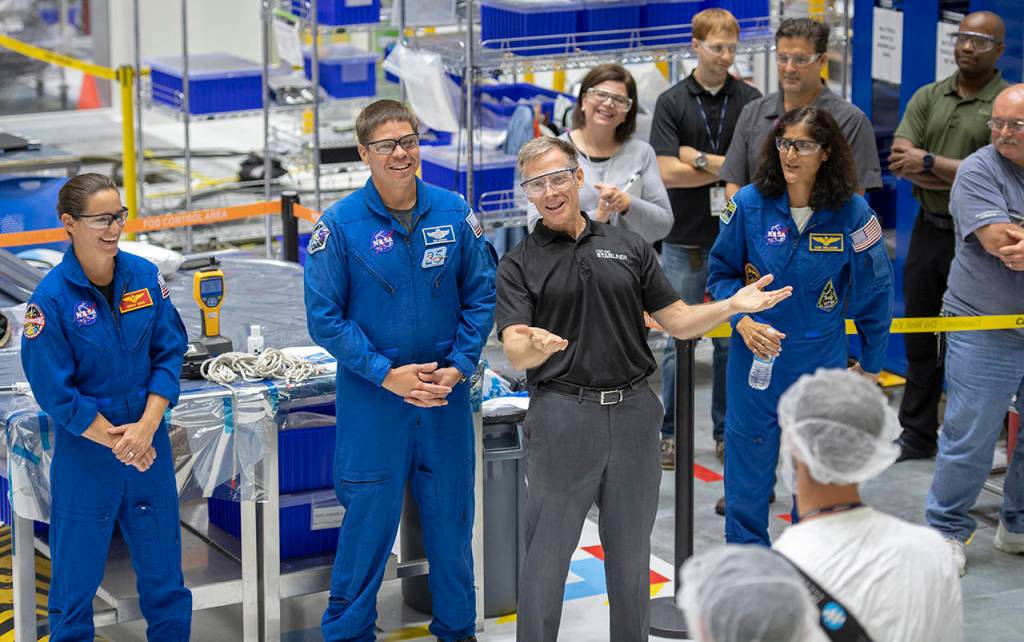 Chris Ferguson (center) and (from left) NASA astronauts Nicole Mann, Bob Behnken and Sunita Williams talk with Boeing employees after they assembled part of the Starliner spacecraft. (Jonathan Newton/Washington Post)