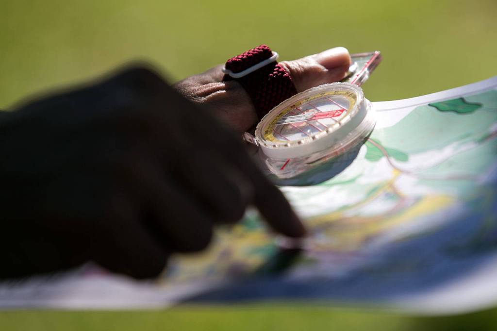 Herald sports writer Nick Patterson looks at a map of the orienteering course at Forest Park in Everett on July 18. (Kevin Clark / The Herald)