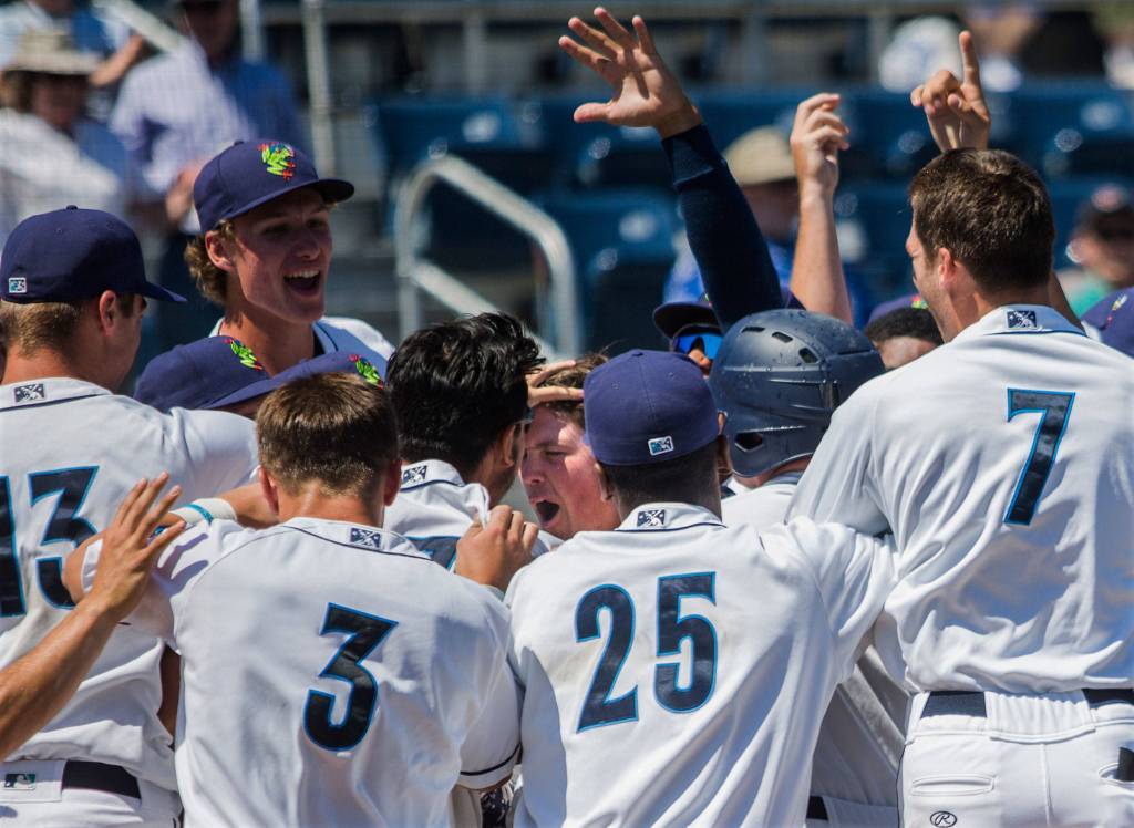 The AquaSox celebrate and pat their teammate Troy Dixon on the head after his game winning home run during the game against Vancouver at Everett Memorial Stadium on Thursday, July 26, 2018 in Everett, Wa. (Olivia Vanni / The Herald)