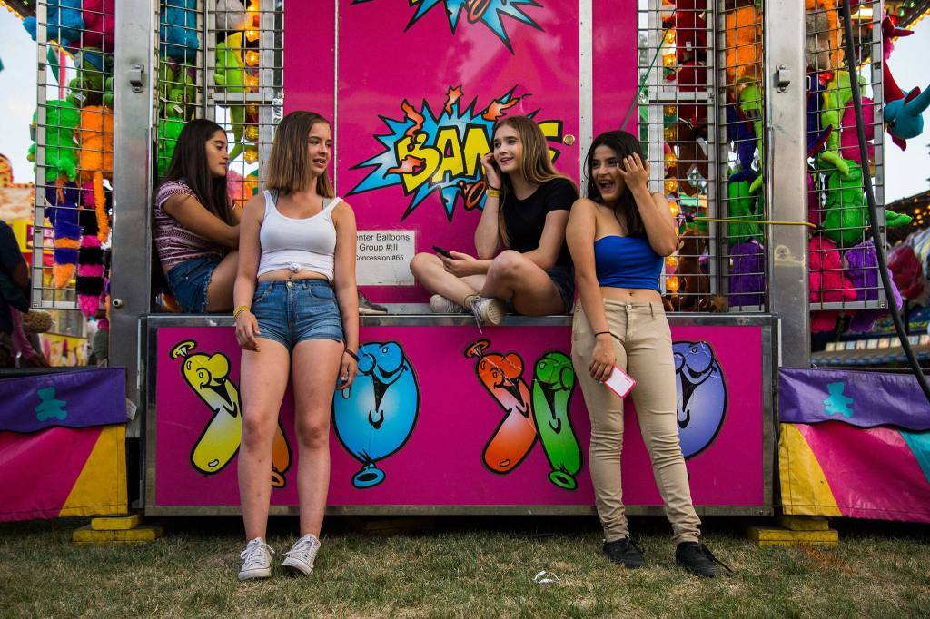 Fiorella Romero, Alora Seaman, Natalie Paige and Jenny Flores hangout during the Tour de Terrace carnival on Friday, July 27, 2018 in Mountlake Terrace, Wa. (Olivia Vanni / The Herald)