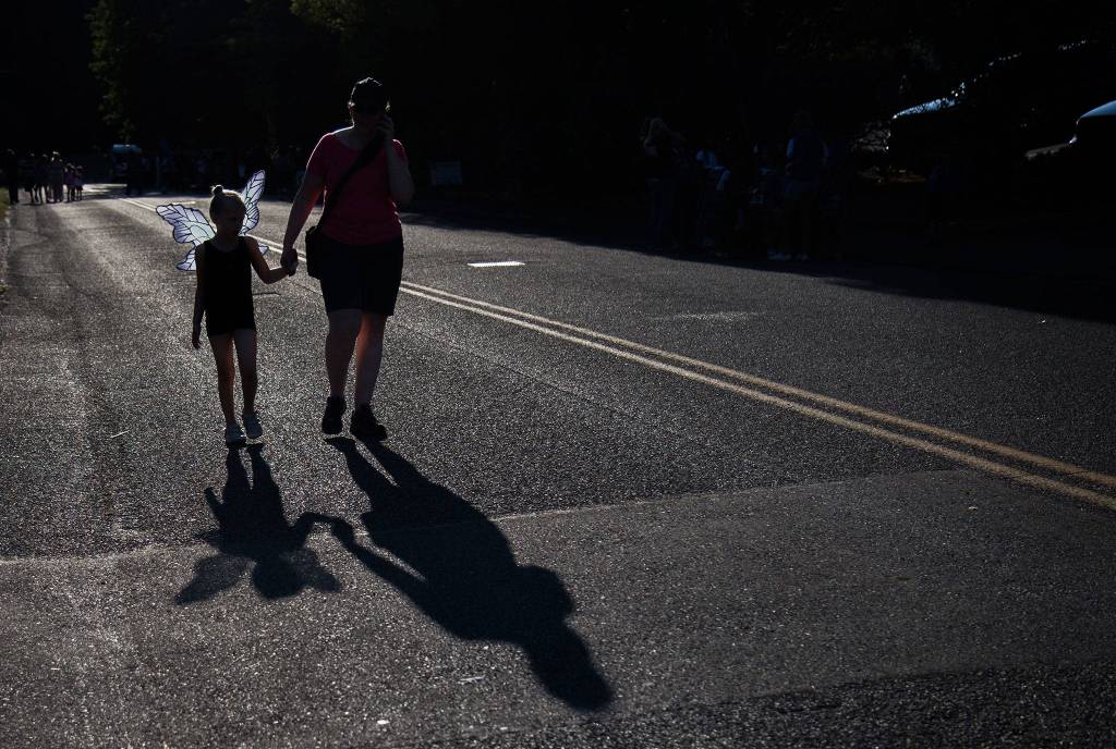 Kristen Falk, 6, holds her moms hand before the start of the Tour de Terrace parade on Friday, July 27, 2018 in Mountlake Terrace, Wa. (Olivia Vanni / The Herald)