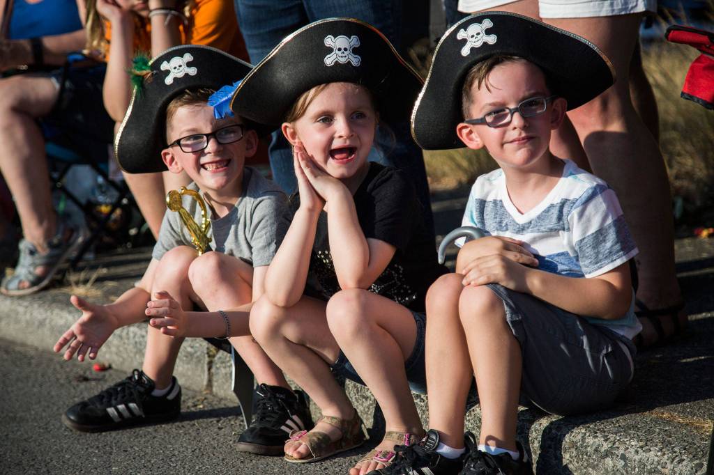 Shane Ramlow, 6, left, Aiden Tillett, 7, and Silas Ramlow, 4, smile as the Seattle Police lead the start of the Tour de Terrace parade on Friday, July 27, 2018 in Mountlake Terrace, Wa. (Olivia Vanni / The Herald)