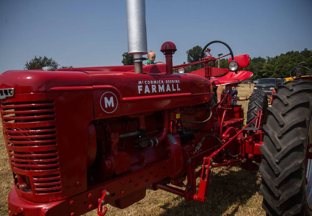 Castiel Knowlston, 1, looks at tractors from his fathers shoulders during the Silvana Fair off of Pioneer Highway on Saturday, July 28, 2018 in Silvana, Wa. (Olivia Vanni / The Herald)