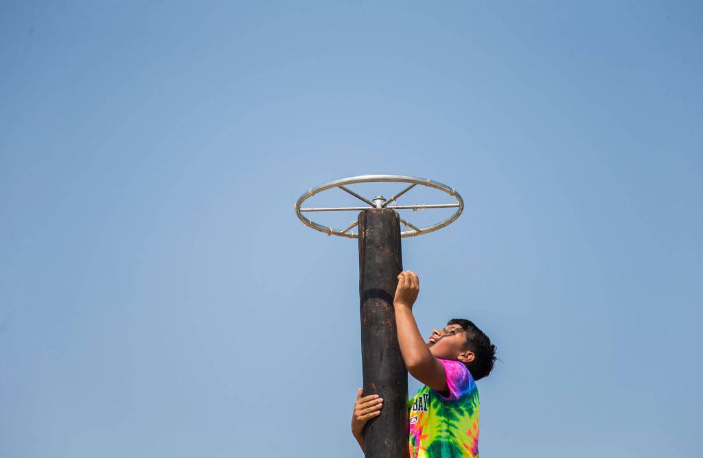 A young boy climbs to the top of a boy obstacle during the Silvana Fair off of Pioneer Highway on Saturday, July 28, 2018 in Silvana, Wa. (Olivia Vanni / The Herald)